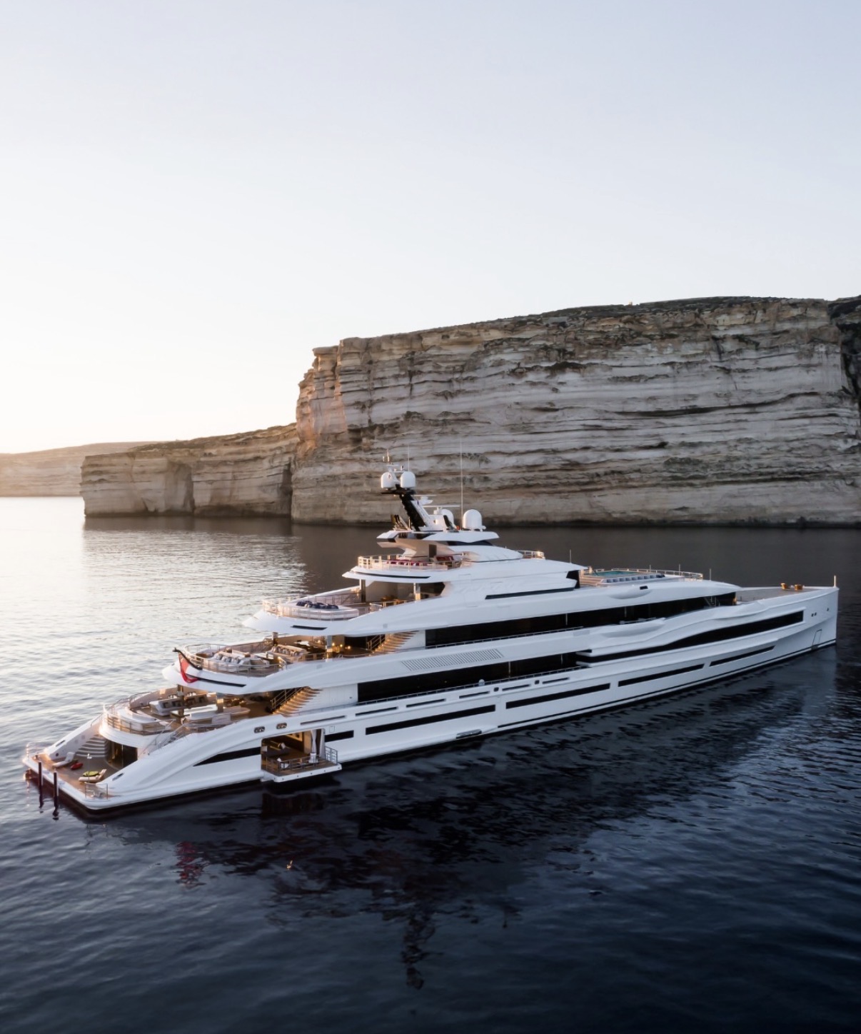 Superyacht at anchor beneath the cliffs